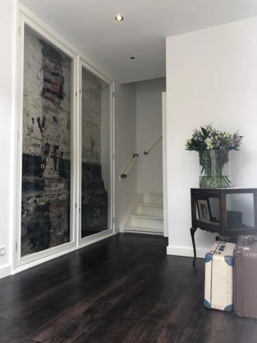 a living room with a large window and a staircase at Pension Montmaertre in Zierikzee