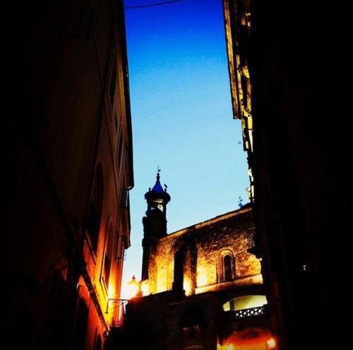 a building with a clock tower in the distance at Hostal León in Trujillo