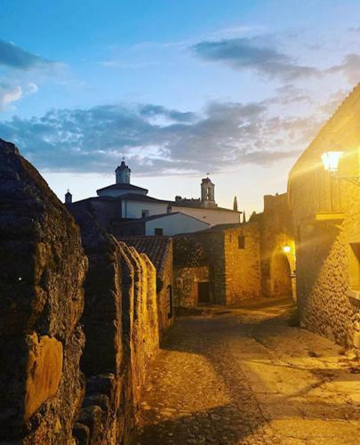 a stone alley with a building in the background at Hostal León in Trujillo
