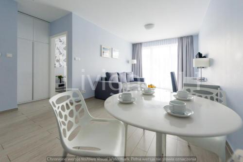 einen weißen Tisch und Stühle im Wohnzimmer in der Unterkunft Apartament Czarna Góra Sienna LIV in Heudorf