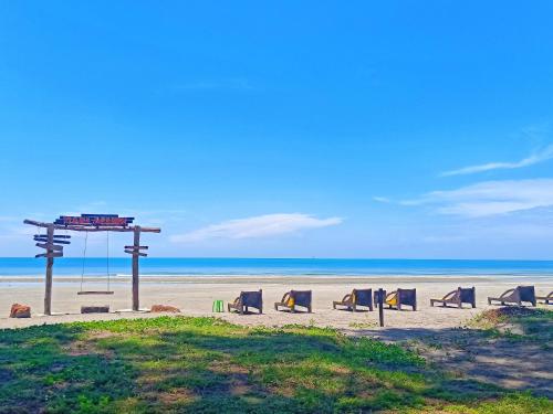 a group of chairs sitting on the beach at Le'Coco Homestay in Tiara Desaru Residence in Desaru