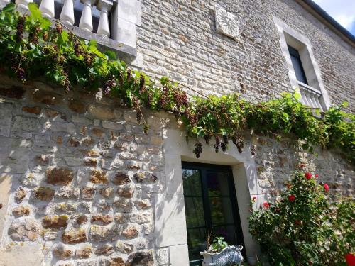 un bâtiment en pierre avec des plantes sur son côté dans l'établissement La Mare aux 3 Diables, à Fresney-le-Vieux