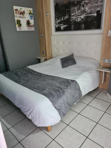 a bedroom with a large bed with white sheets at Initial by balladins Lyon / Chanas in Chanas