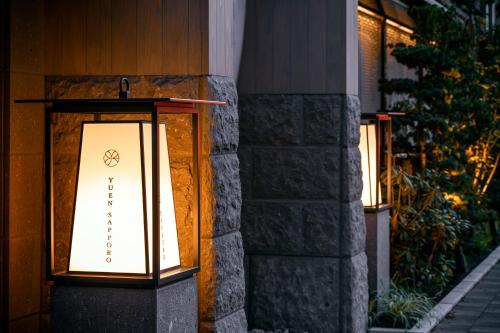 札幌ONSEN RYOKAN Yuen Sapporo的建筑物一侧的两盏灯