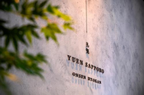 a wall with writing on the side of a building at ONSEN RYOKAN Yuen Sapporo in Sapporo