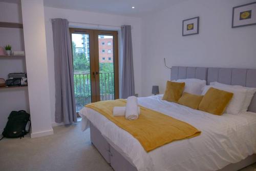 um quarto com uma grande cama branca com almofadas amarelas em Maplewood properties - St Albans one bedroom luxurious flat em Saint Albans