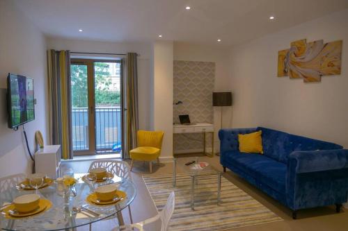a living room with a blue couch and a table at Maplewood properties - St Albans one bedroom luxurious flat in St. Albans