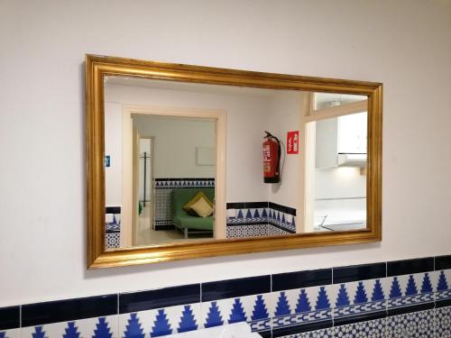 a mirror on a wall with a fire extinguisher at Alojamiento Temporal Corazón Madrid in Madrid