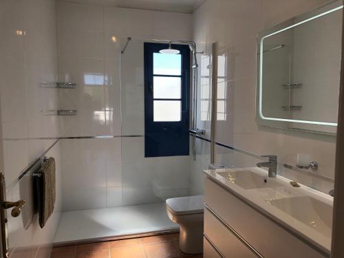 a bathroom with a sink and a toilet and a window at Locarno in Puerto Calero