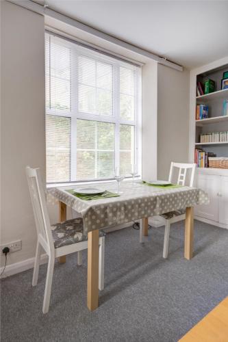 a dining room with a table and two chairs at The Courtyard Cirencester in Cirencester