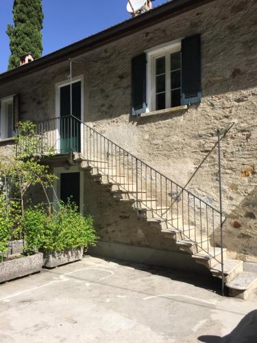 a stone building with stairs and a window at Camping & Resort Valle Romantica in Cannobio