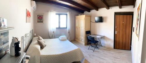 ein Schlafzimmer mit einem Bett und einem Schreibtisch in einem Zimmer in der Unterkunft LA PICCOLA DEPENDANCE in Tuscania
