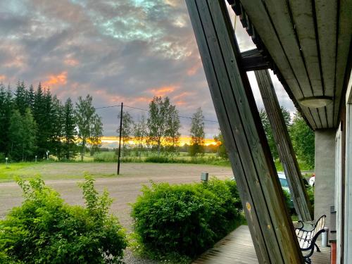 Blick auf einen Park von einer Veranda mit einer Bank in der Unterkunft Kartano Kievari in Äänekoski
