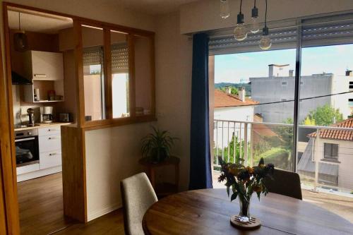 een keuken en eetkamer met een tafel en een groot raam bij Le Pot au Lait - FIBRE - CLIMATISATION in Périgueux