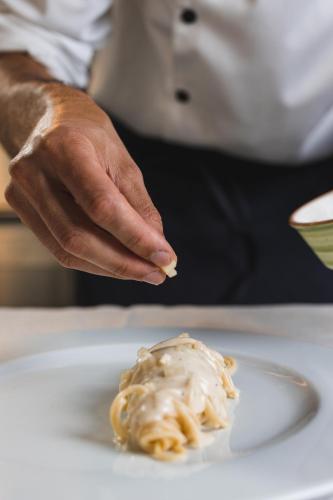 a person holding a piece of food on a plate at Relais Riserva di Fizzano in Castellina in Chianti