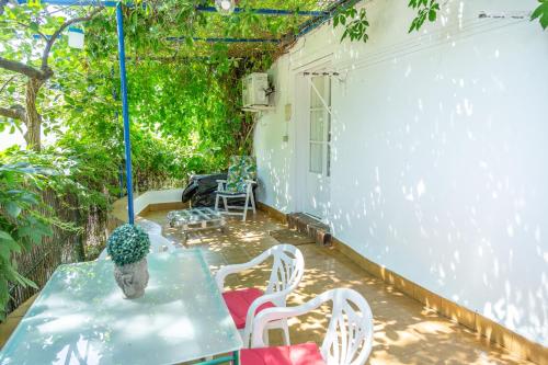 a patio with a table and white chairs and a table at Casita Collado 3 in Alájar