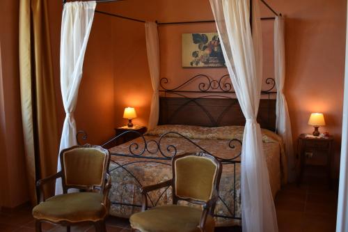 sypialnia z łóżkiem z 2 krzesłami i 2 lampami w obiekcie Agriturismo Il Santo w Greve in Chianti