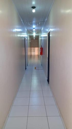 an empty hallway with doors and ailed floor at Hotel Rilton in Carolina