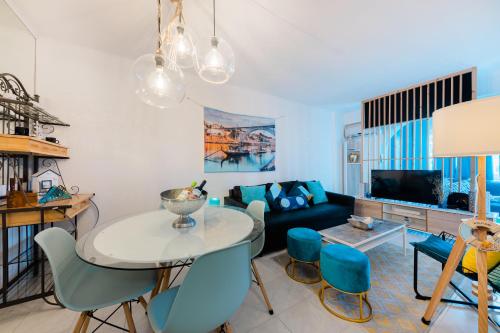 a living room with a table and blue chairs at 2 Room Condo - 5 mins from Costa da Caparica Beach & Bars in Costa da Caparica