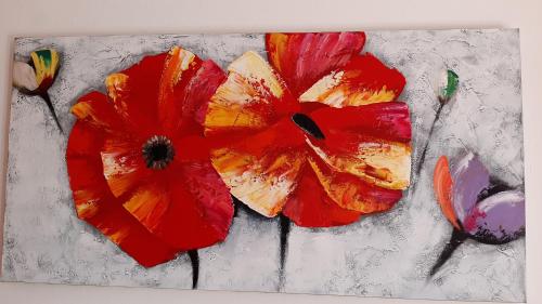 a painting of a red flower on a table at Le Palme Sona in Sona