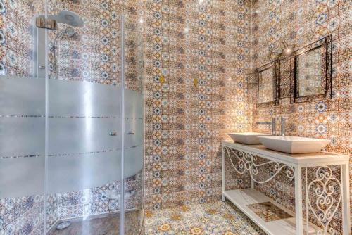 a bathroom with a glass shower and two sinks at Ryad Mogador Liège in Liège