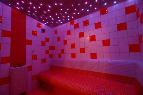 a red and white bathroom with a tub with lights at Hotel Skicentrum in Harrachov