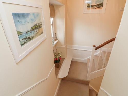 a staircase in a house with a painting on the wall at Fairfield Cottage in Boscastle