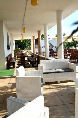 a patio with white furniture and tables and chairs at Villa Grazia in Capo Vaticano