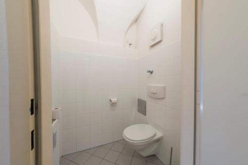 a white bathroom with a toilet and a shower at Cozy Kunsthaus GRAZ in Graz