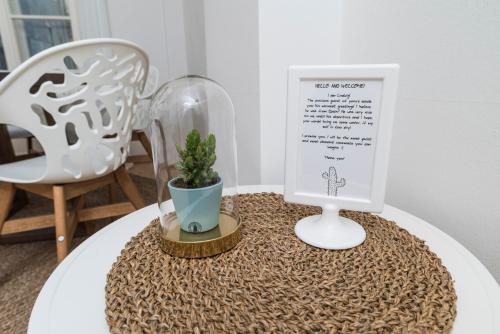 a table with a sign and a potted plant on it at Cozy Kunsthaus GRAZ in Graz