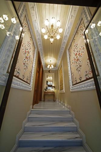 a hallway with a staircase with a chandelier at Celine Hotel - Ottoman Mansion in Istanbul