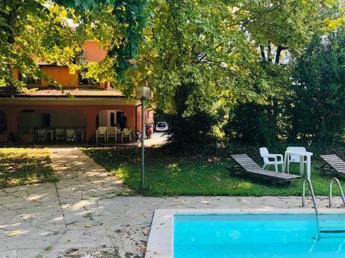 een zwembad in een tuin met een huis en stoelen bij I POGGI DI S.CATERINA in Sarzana