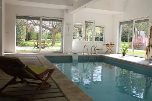 Cette maison dispose d'une piscine avec une chaise et des fenêtres. dans l'établissement Villa Maria, à Petit-Réderching