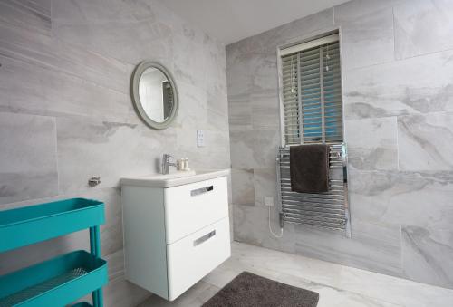 a bathroom with a sink and a mirror at Sundown in Bude