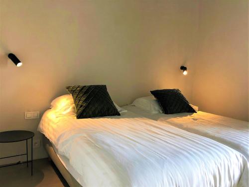 a bedroom with a large white bed with two pillows at Groot Noordhof in Nieuwpoort
