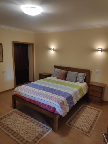 una camera da letto con un letto con un piumone a righe di Casa do Pomarelho a Póvoa de Lanhoso