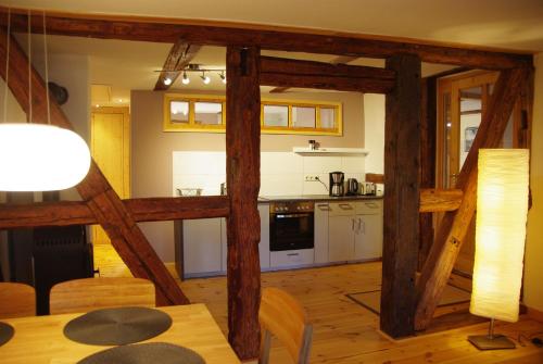 eine Küche mit Holzbalken und einem Tisch im Zimmer in der Unterkunft Gästehaus in Sülbeck in Einbeck