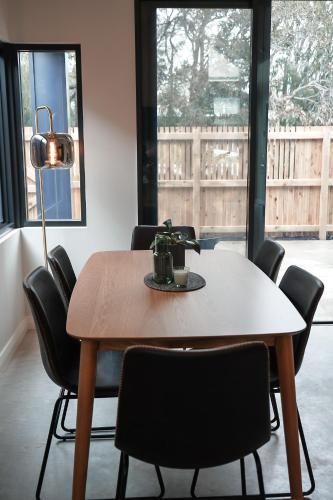 a dining room table with chairs and a lamp at Melo Studios in Dunsborough