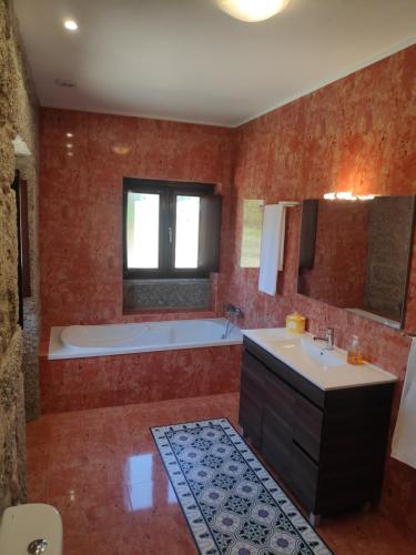 uma grande casa de banho com banheira e lavatório em Casa do Pomarelho em Póvoa de Lanhoso