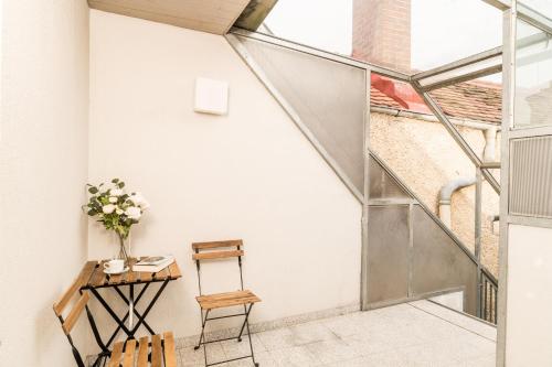a room with a table and chairs and a staircase at Cozy Kunsthaus GRAZ in Graz