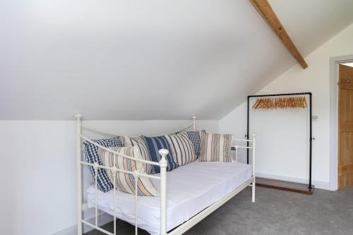 a white bed with pillows on it in a room at Hastings Retreat Rural barn conversions with Private Lake in Ashby de la Zouch