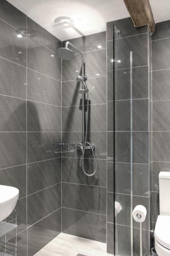 a shower with a glass door in a bathroom at Hastings Retreat Rural barn conversions with Private Lake in Ashby de la Zouch