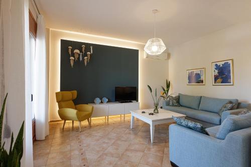 ein Wohnzimmer mit einem blauen Sofa und einem Tisch in der Unterkunft Sea La Vie house, close to the beach, By ThinkVilla in Panormos