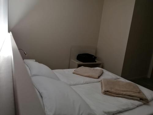 a room with two beds with white sheets and a pillow at Hotel Europa in Dossobuono