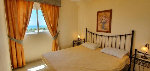 1 dormitorio con cama y ventana grande en Corner Sea View Penthouse with 95m² terraces en Cabopino