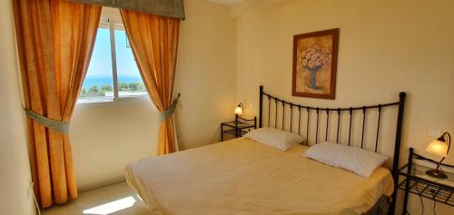 a bedroom with a bed and a large window at Corner Sea View Penthouse with 95m² terraces in Cabopino