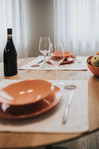 a wooden table with plates and wine glasses on it at Bed's Apartments in Soave