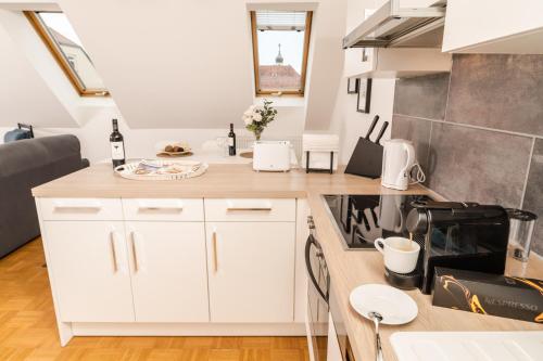a kitchen with white cabinets and a counter top at Cozy Kunsthaus GRAZ in Graz