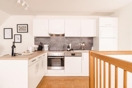 a kitchen with white cabinets and a stove top oven at Cozy Kunsthaus GRAZ in Graz