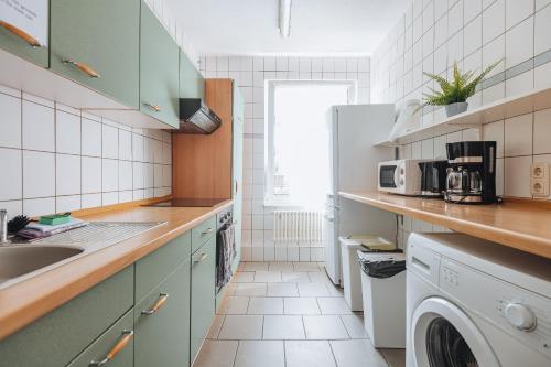eine Küche mit Spüle, Waschmaschine und Trockner in der Unterkunft XXL Ferienhaus Dierhagen Strand in Dierhagen